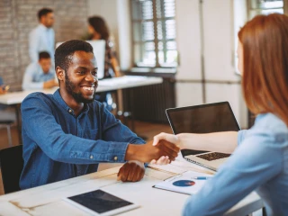 Young man in a job interview shakes hands with a young woman