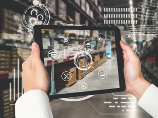 person holds up tablet to scan warehouse stock