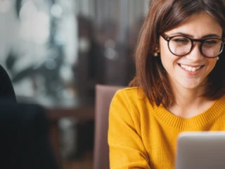 Woman smiling at computer screen