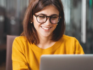 Woman smiling at computer screen