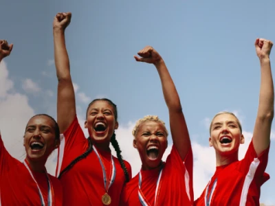 Four women with medals cheering