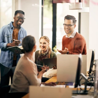 group of smiling people having a discussion in the workplace