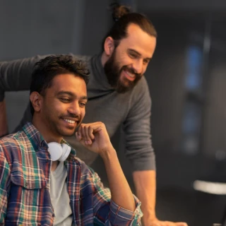 two people smiling at a desk