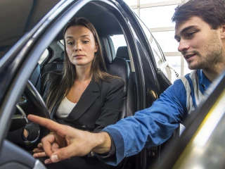 picture of a car mechanic explaining something to a customer